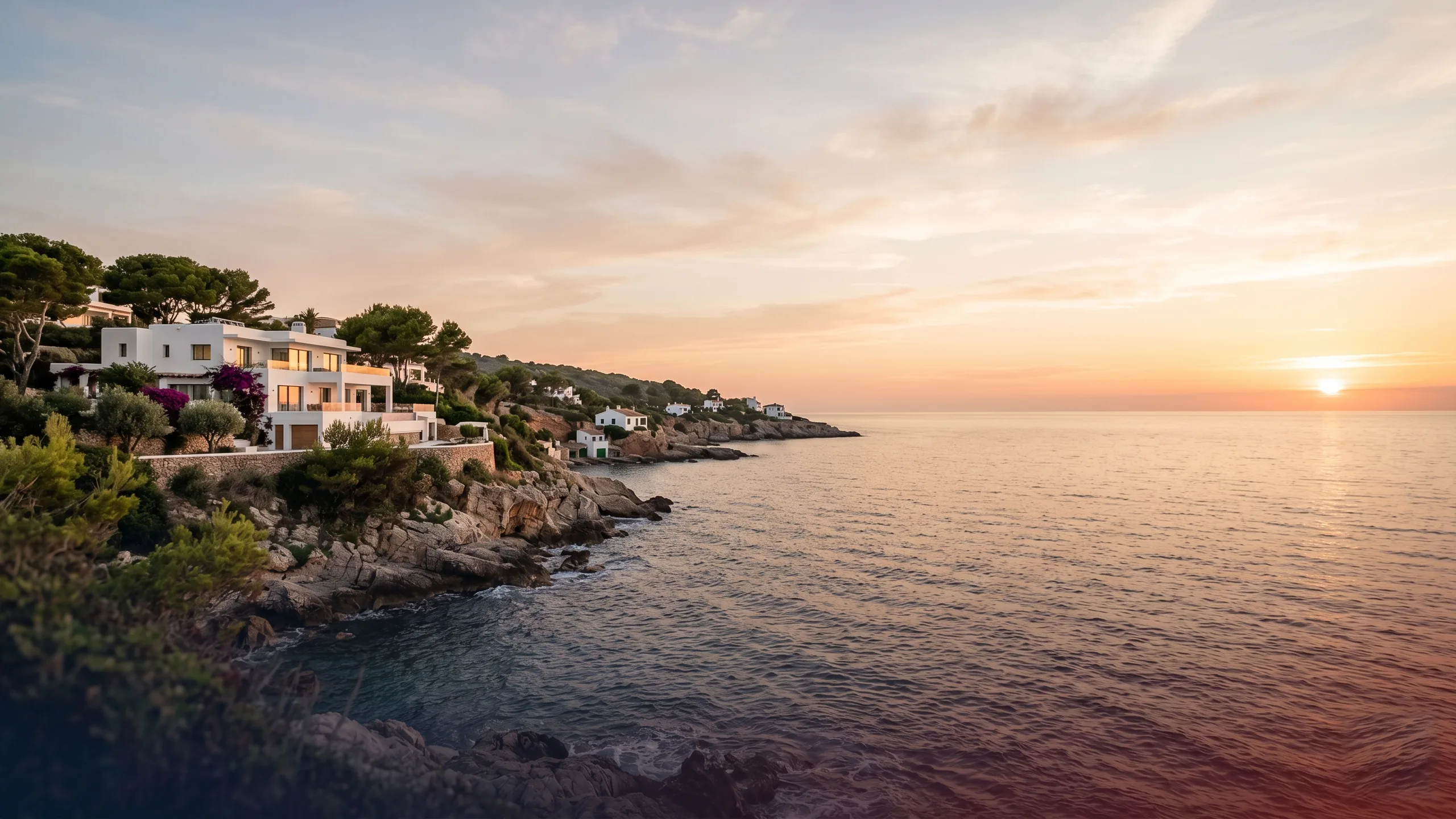 A villa above a Mediterranean cove at sunset, the image most people hold when buying property in Spain as a foreigner